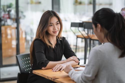 Woman listens to friend talk at cafe about PHP