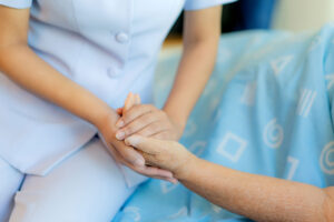 Woman holds hands with patient during partial hospitalization