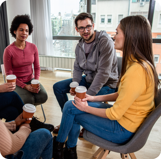 People gather in group therapy and drink coffee