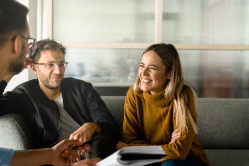 Woman smiles while listening to IOP counselor while her husband looks on