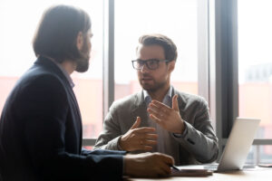 Man speaks to colleague about addiction treatment for a client