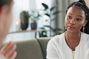 Woman listens as her therapist talks to her about process addiction treatment